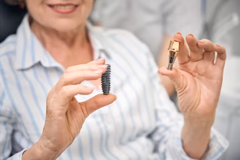 Patient smiling after replacing a missing tooth with a dental implant