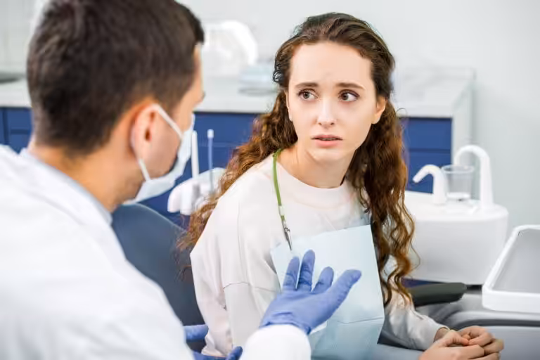 Dentist discussing dry mouth symptoms with a patient during a dental examination