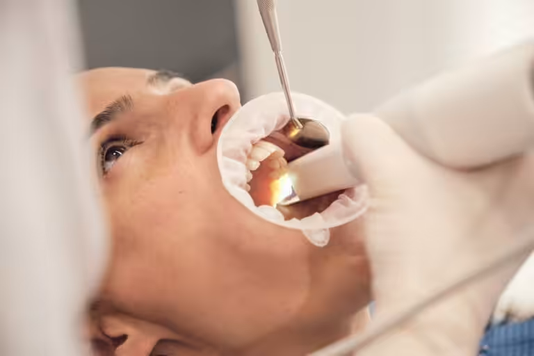 Dentist examining tooth enamel for signs of acid erosion